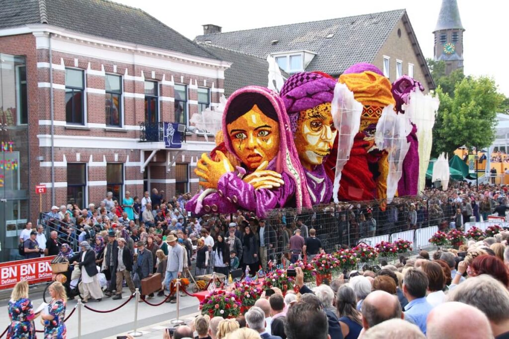 a parade float of many heads made from dahlia flowers